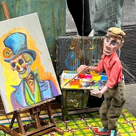 عروسک خیمه‌شب‌بازی که می‌رقصد و نقاشی می‌کند